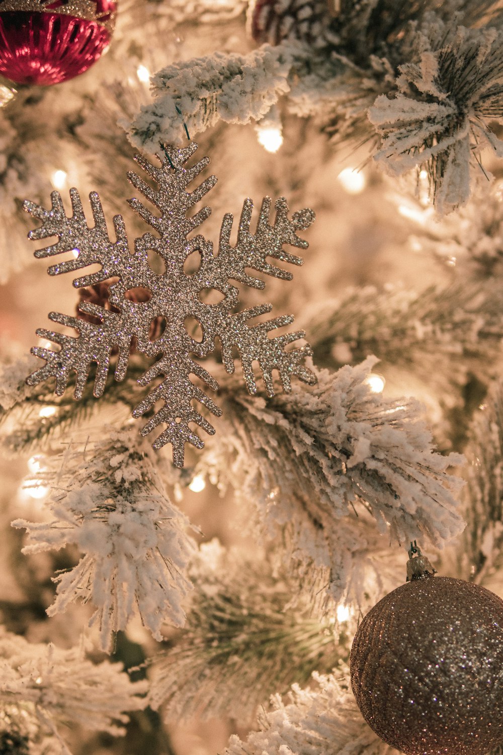 a close up of a christmas tree with a snowflake ornament