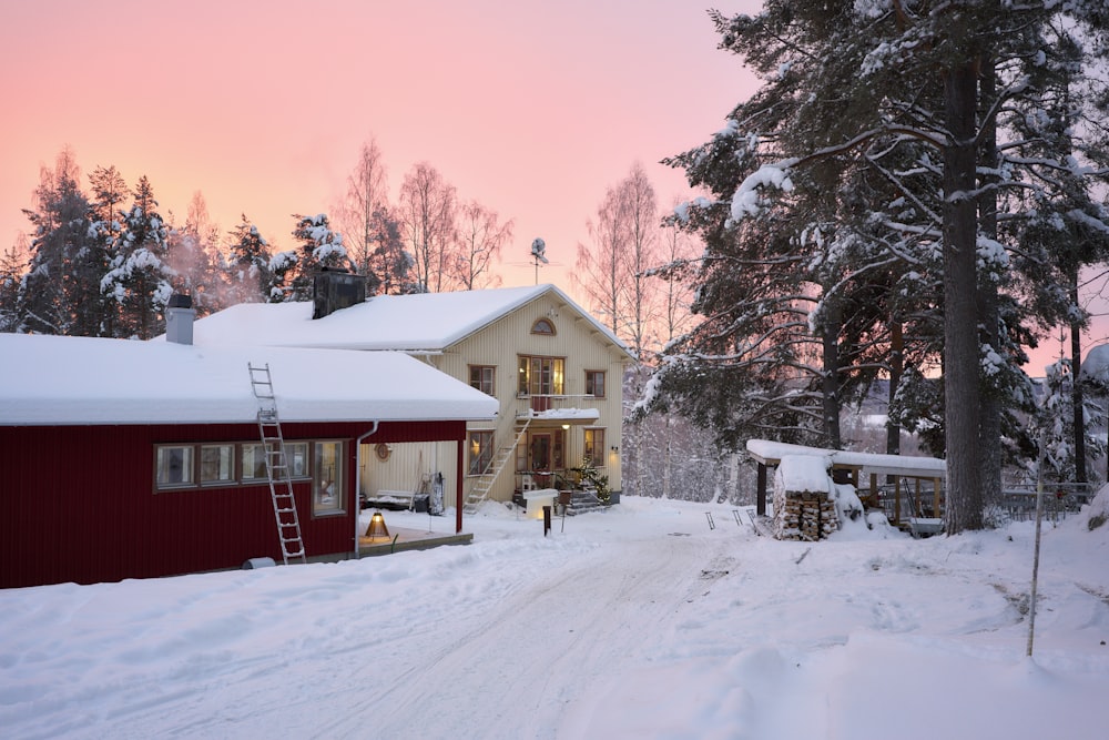 a red house in the middle of a snowy forest