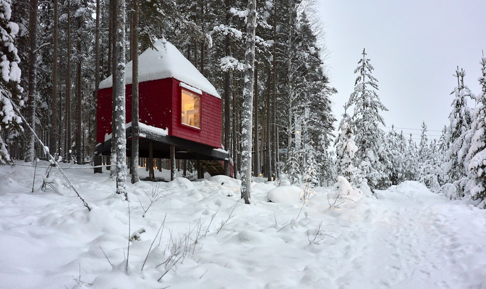 Una cabaña roja en medio de un bosque nevado