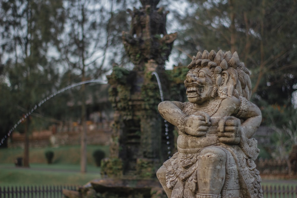 a statue of a man holding a bird in a park