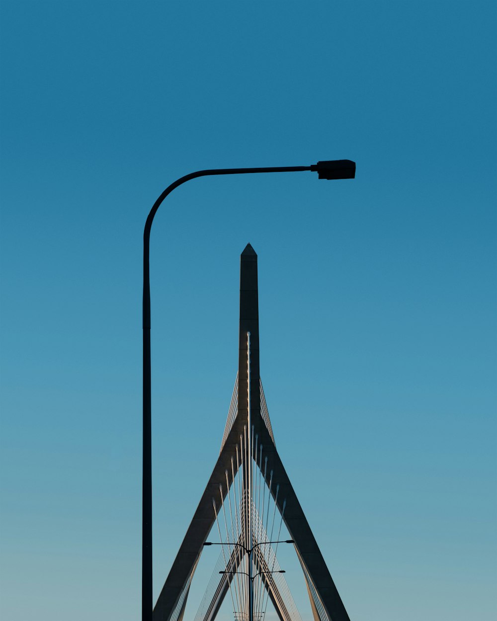 eine Straßenlaterne an einem Mast mit blauem Himmel im Hintergrund