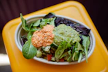 A colorful bowl of fresh California-style salad with Argentine olives and queso fresco.