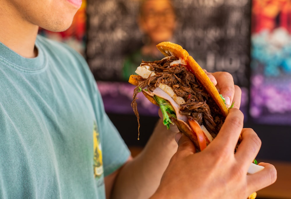 a close up of a person holding a sandwich