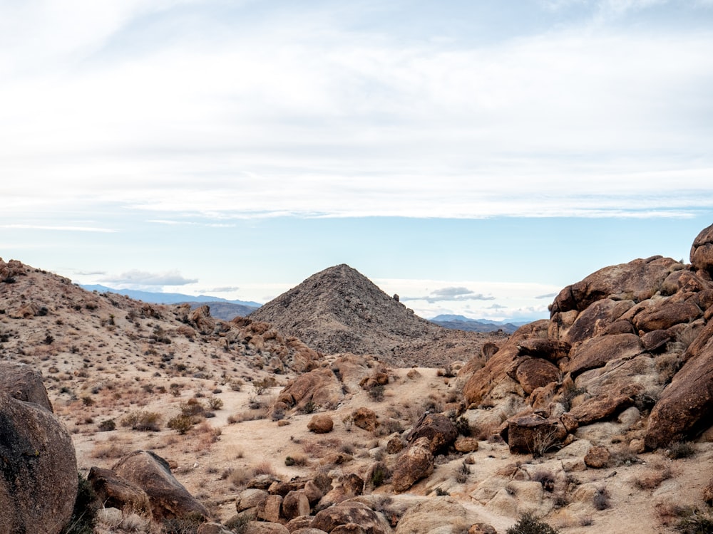 a rocky landscape with a mountain in the distance