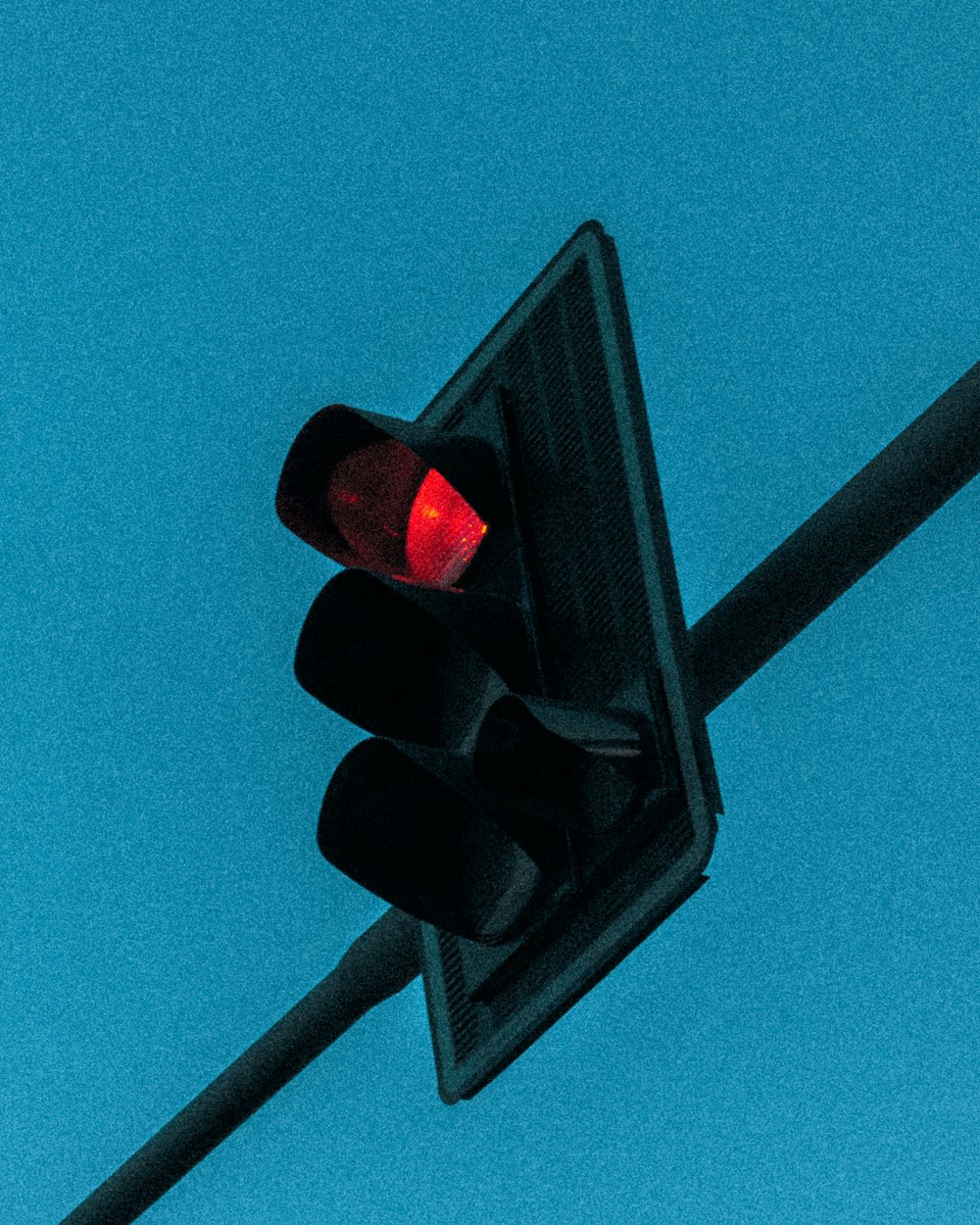 a traffic light on a pole with a blue sky in the background