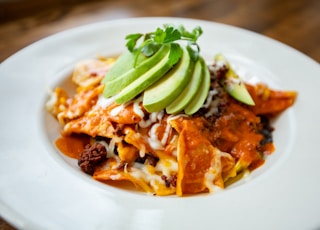 a plate of mexican food with avocado on top