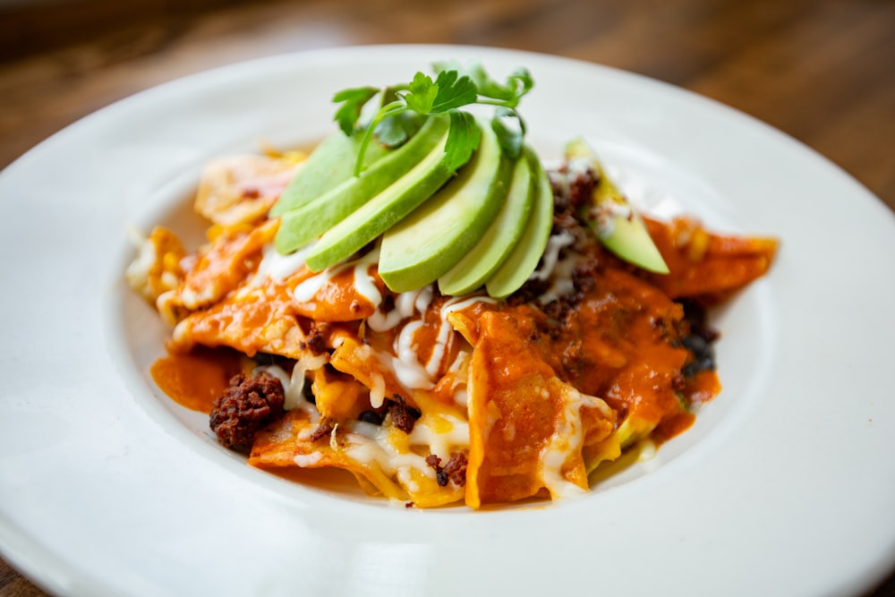 a plate of mexican food with avocado on top