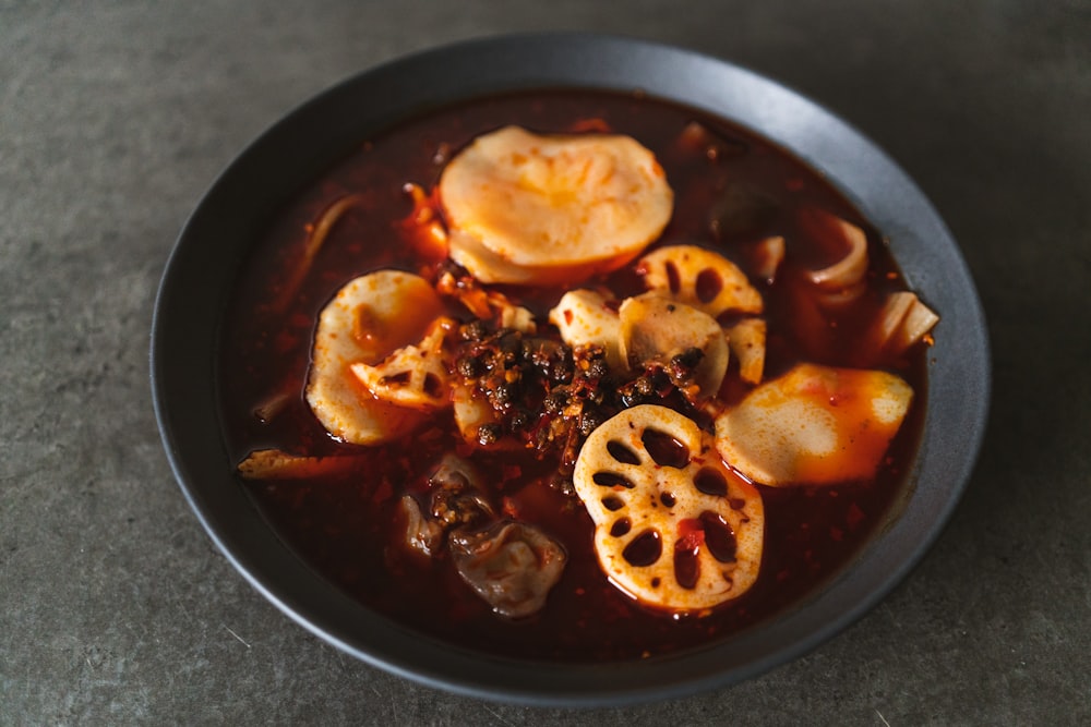 a bowl of soup with dumplings and meat