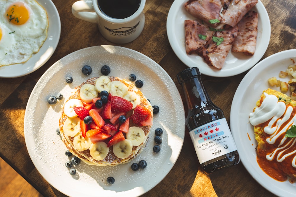 a table topped with plates of food and a cup of coffee