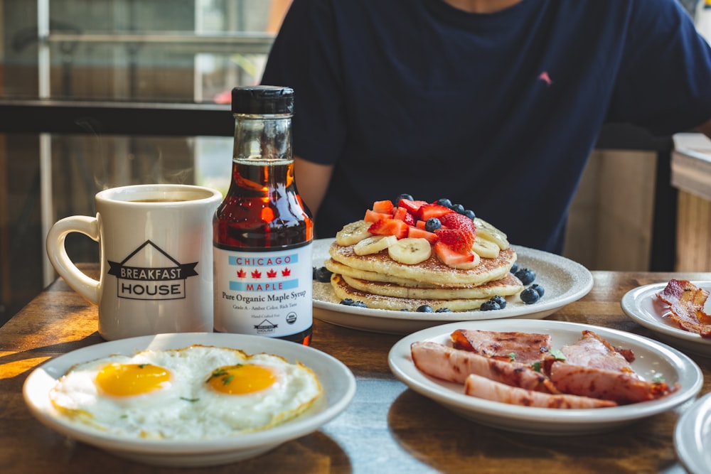 a man sitting at a table with breakfast foods