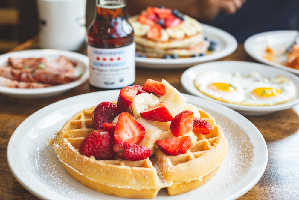 a plate of waffles with strawberries on top