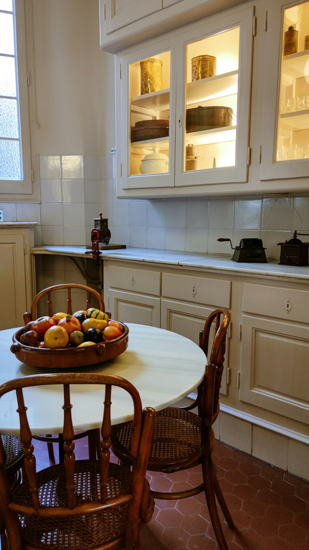 a bowl of fruit on a table in a kitchen