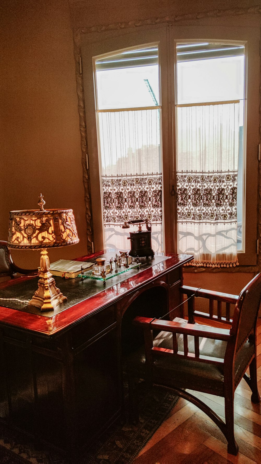 uma mesa com uma cadeira e uma lâmpada em uma sala