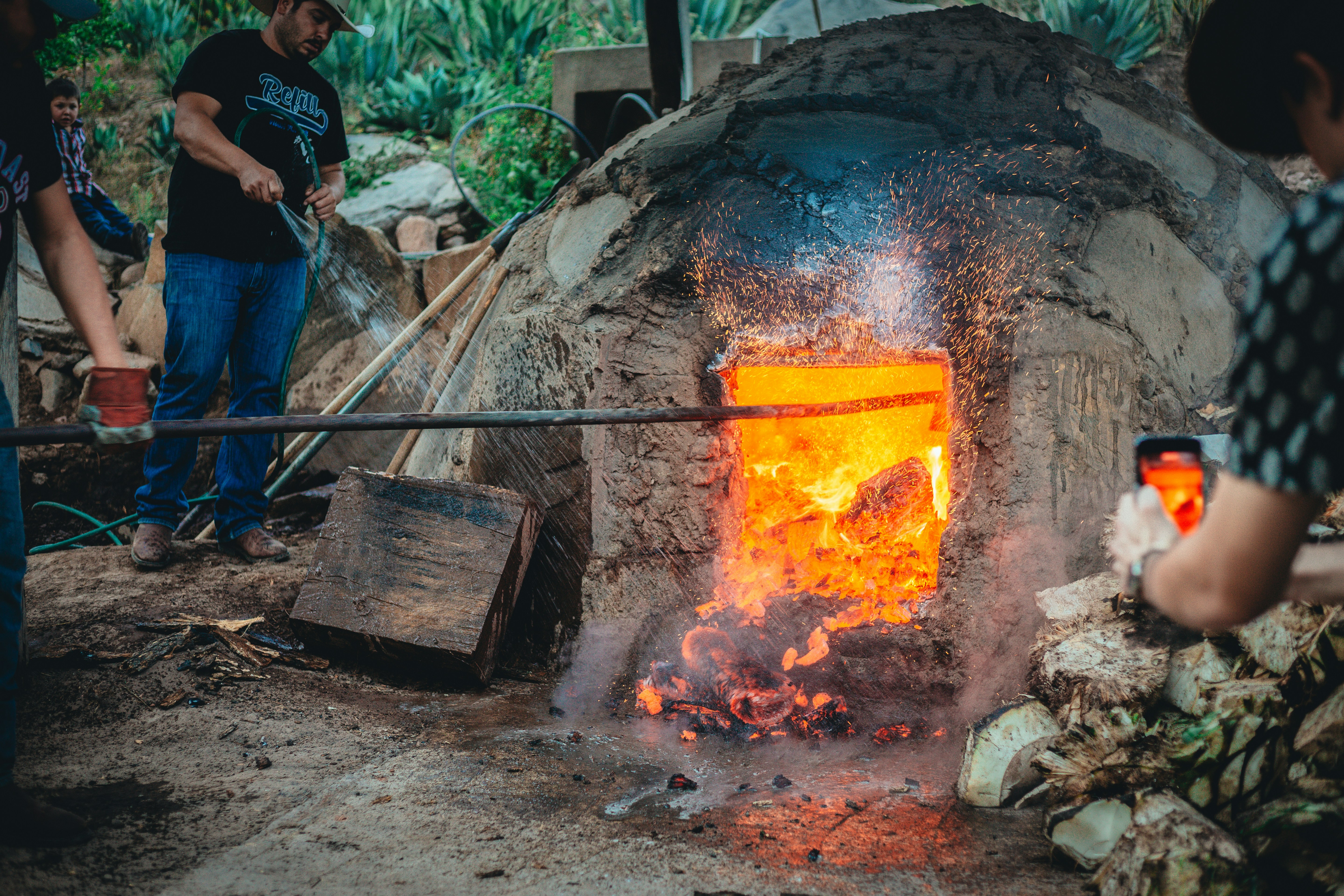 a group of people standing around a stone oven