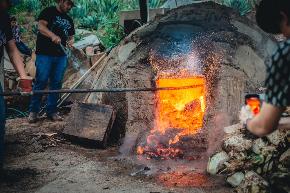 a group of people standing around a stone oven