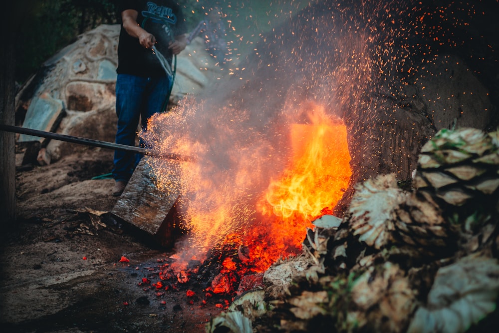 a man standing next to a pile of fire