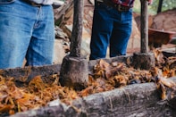 a couple of men standing next to a pile of wood