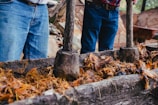 a couple of men standing next to a pile of wood