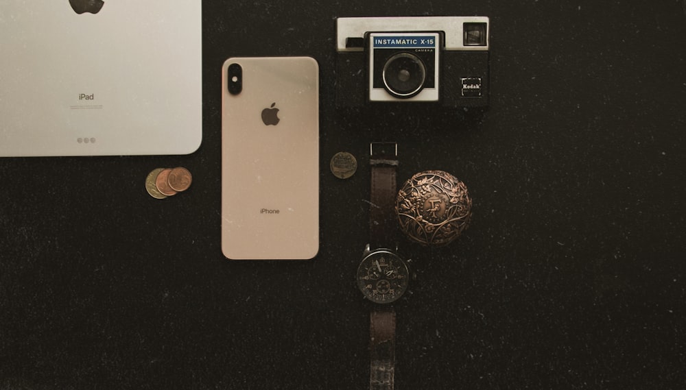 an iphone, watch, and other items on a table