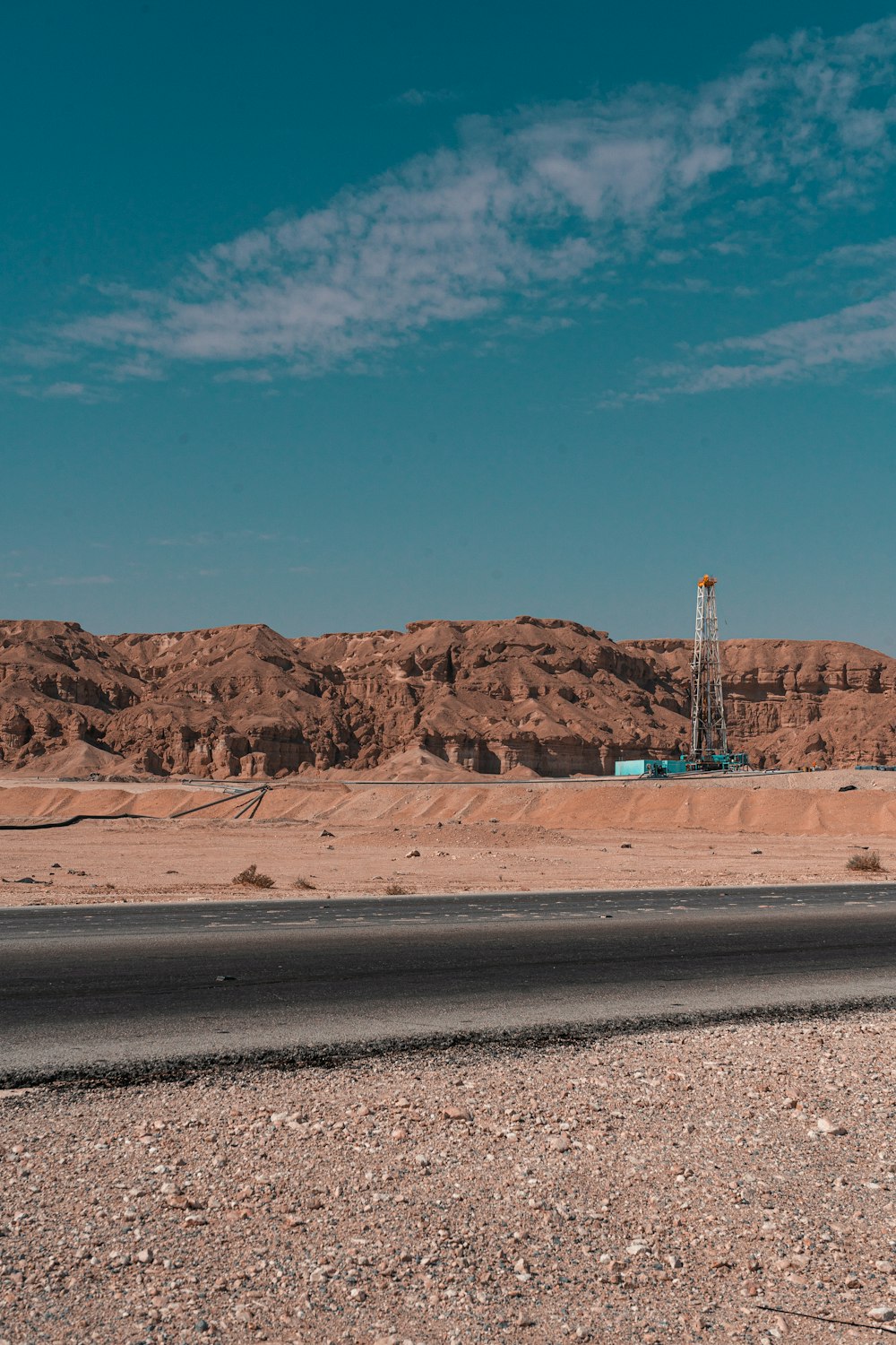 Ein Lastwagen, der mitten in einer Wüste eine Straße entlang fährt