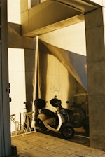 A sleek electric scooter parked outside a modern office building at sunset.