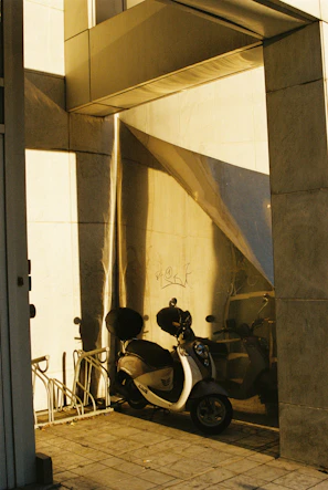 Electric scooter parked beside a contemporary building with reflective glass.