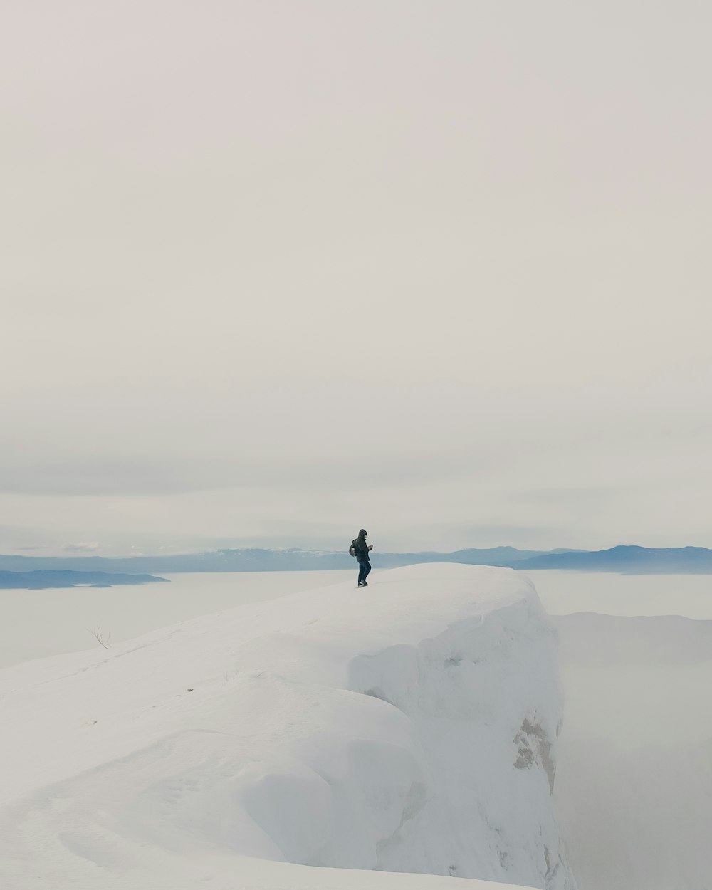 a man standing on top of a snow covered mountain