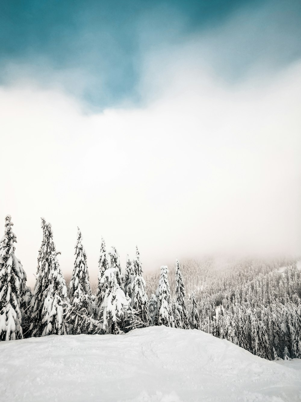 a person riding a snowboard down a snow covered slope