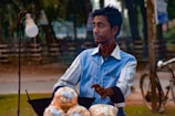 A candid moment of a street vendor in Thailand, caught mid-motion with a contemplative expression.
