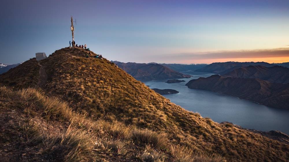 a cross on top of a hill with a lake in the background