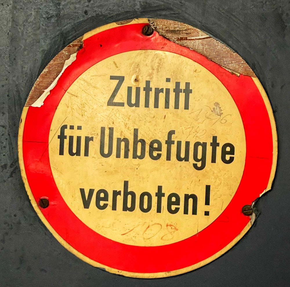 Un panneau rouge et jaune sur lequel on peut lire Zuritt Fur Unbefuge ve