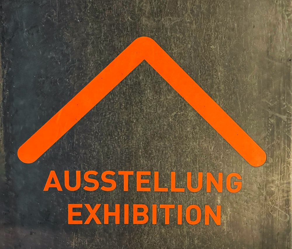 Un panneau orange qui dit Austellung Exhibition