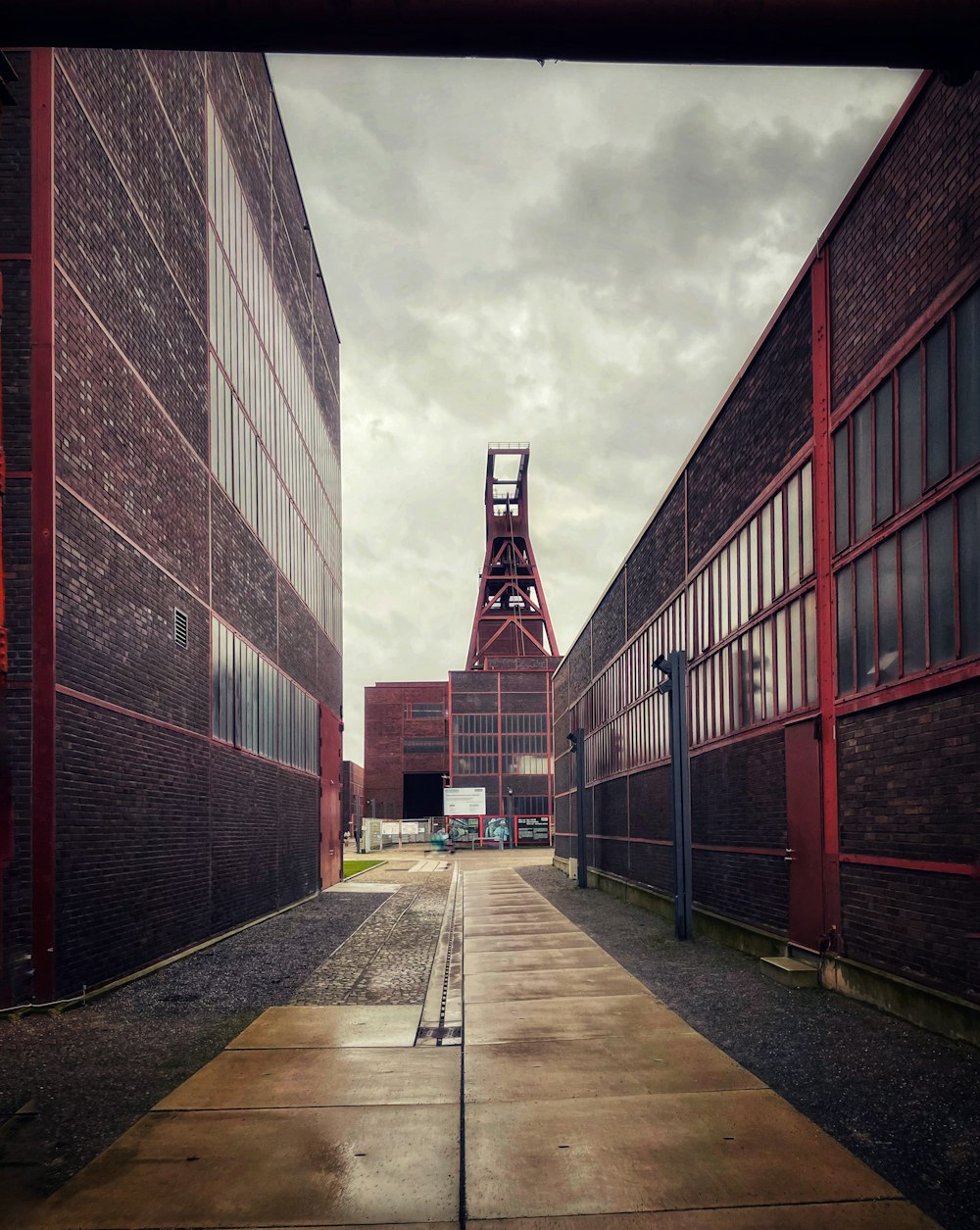 a walkway between two brick buildings on a cloudy day