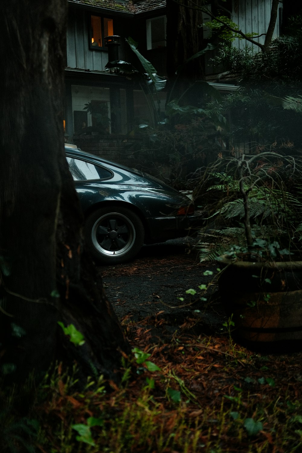 a car parked in front of a house in the woods