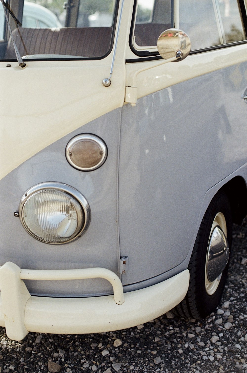 a gray and white vw bus parked in a parking lot