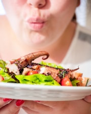 a woman is holding a plate of food