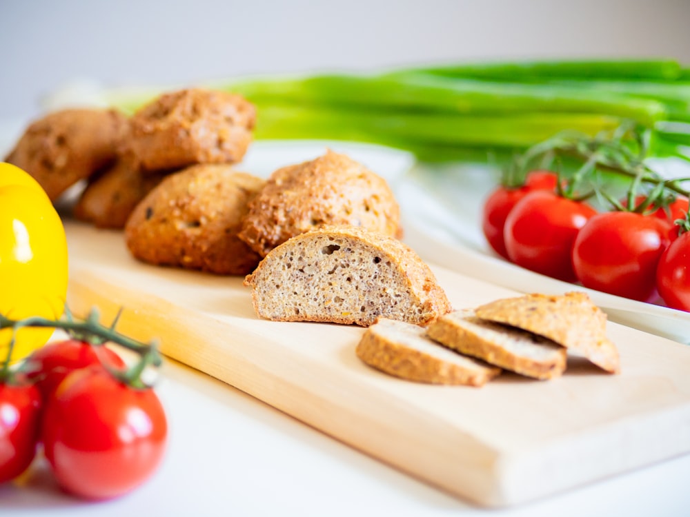 a cutting board topped with sliced bread and tomatoes