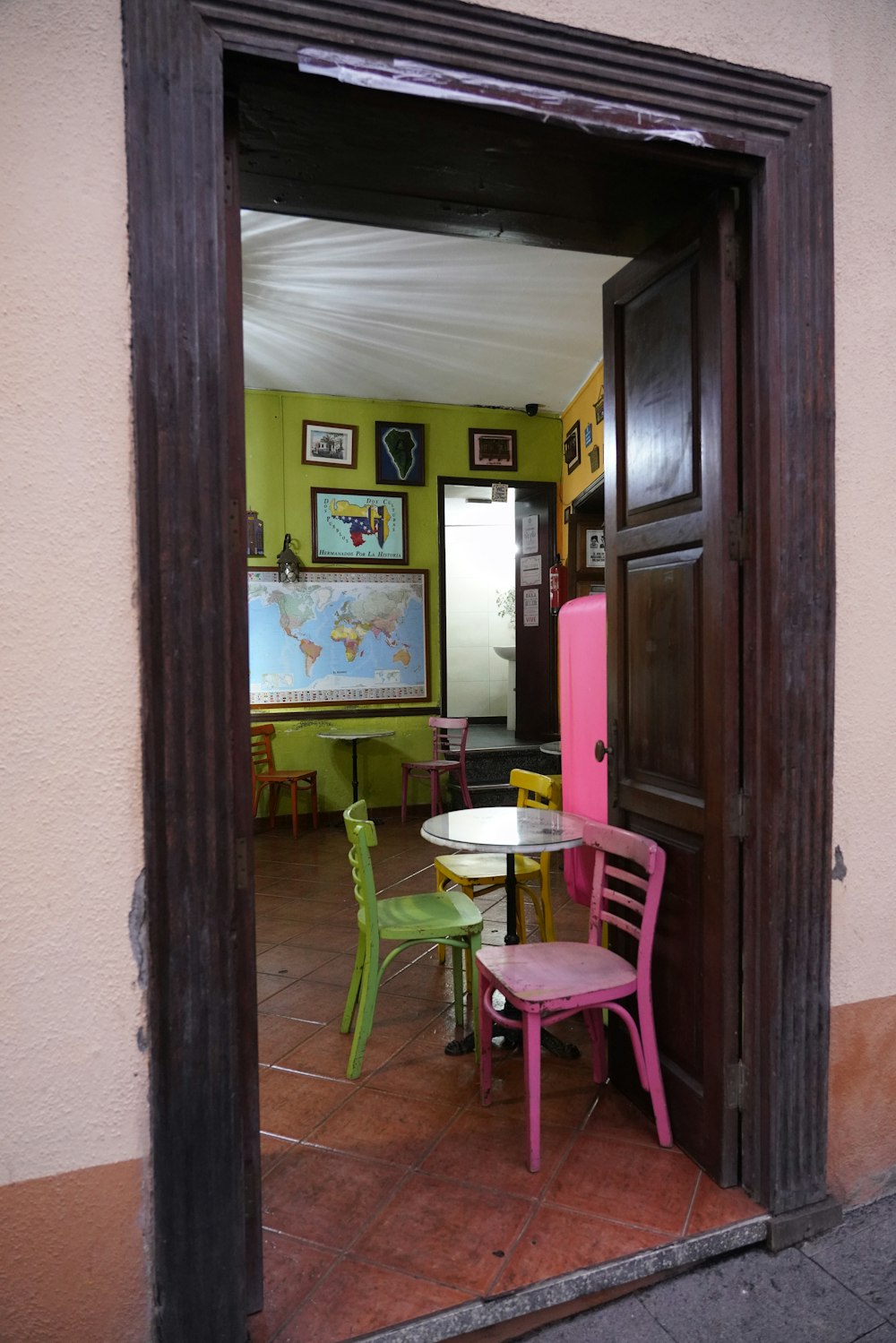 a room with a table, chairs and a map on the wall