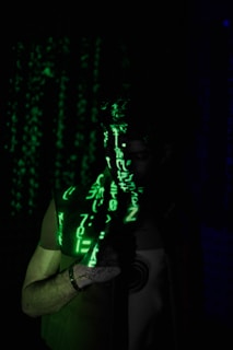 a man standing in the dark with a green light on his face