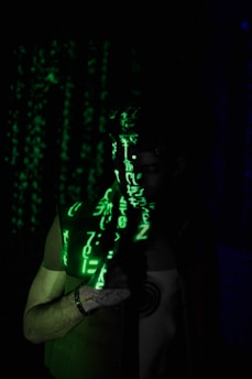 a man standing in the dark with a green light on his face
