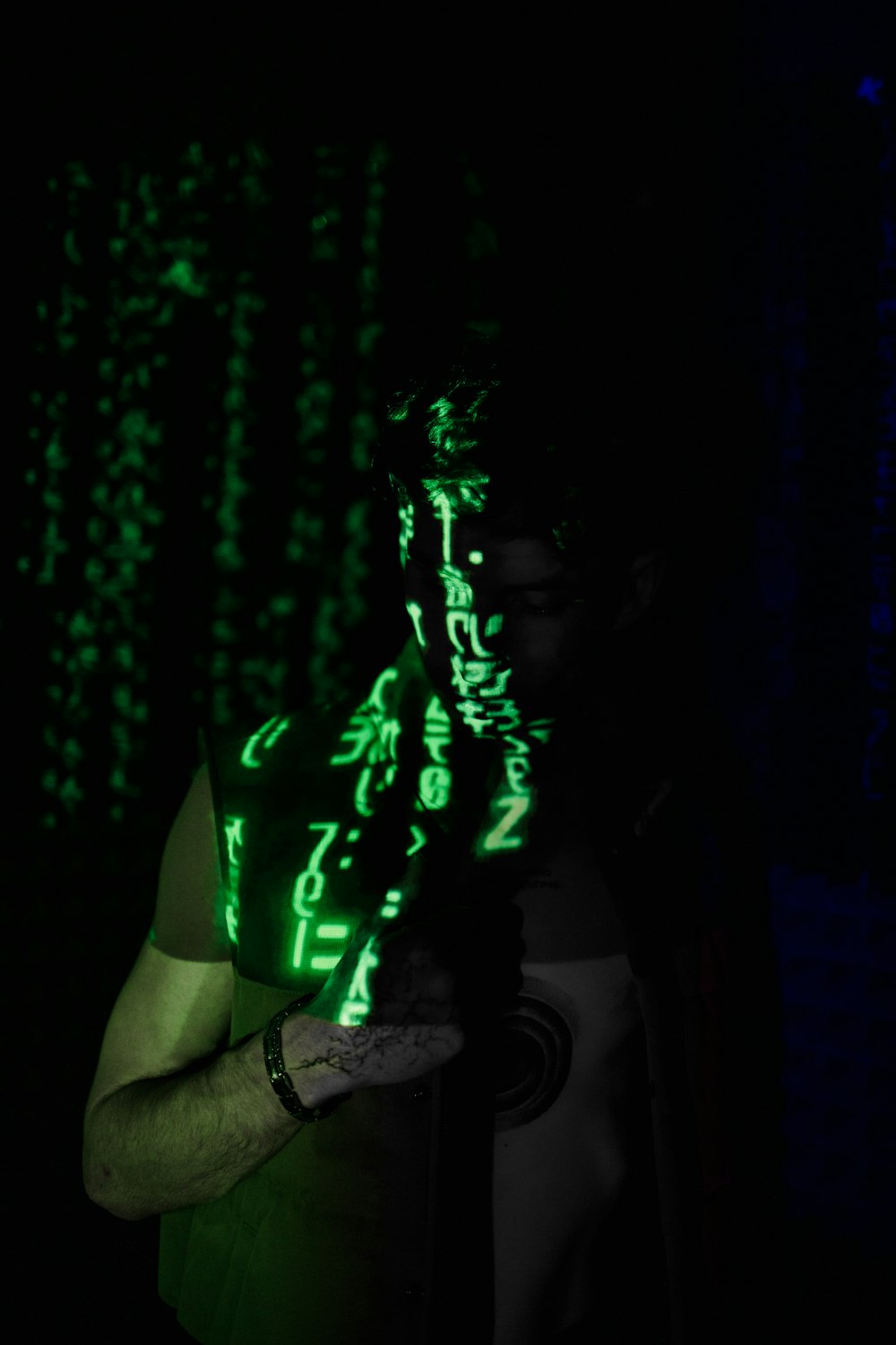 a man standing in the dark with a green light on his face