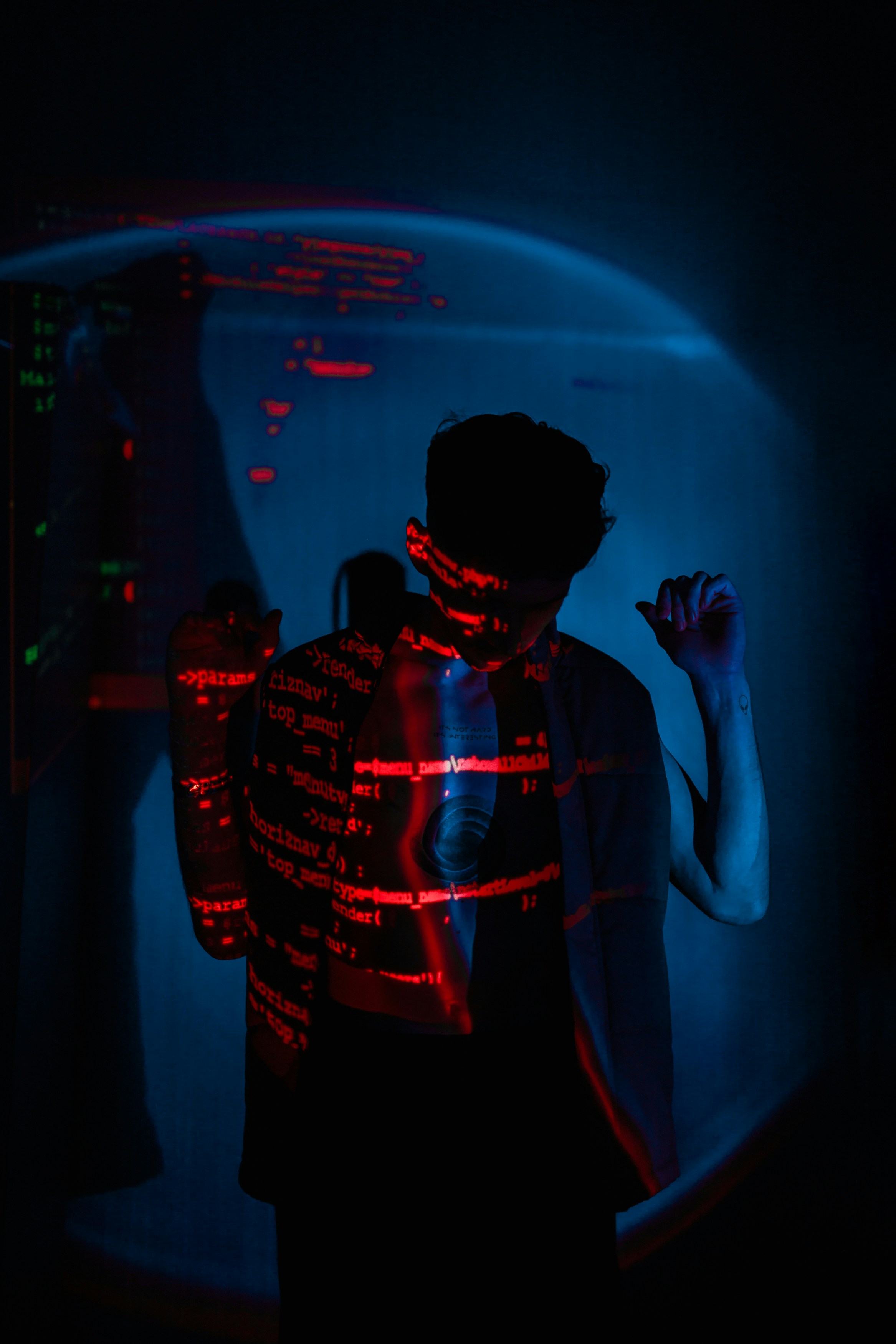 a man standing in a dark room with a red light around his neck