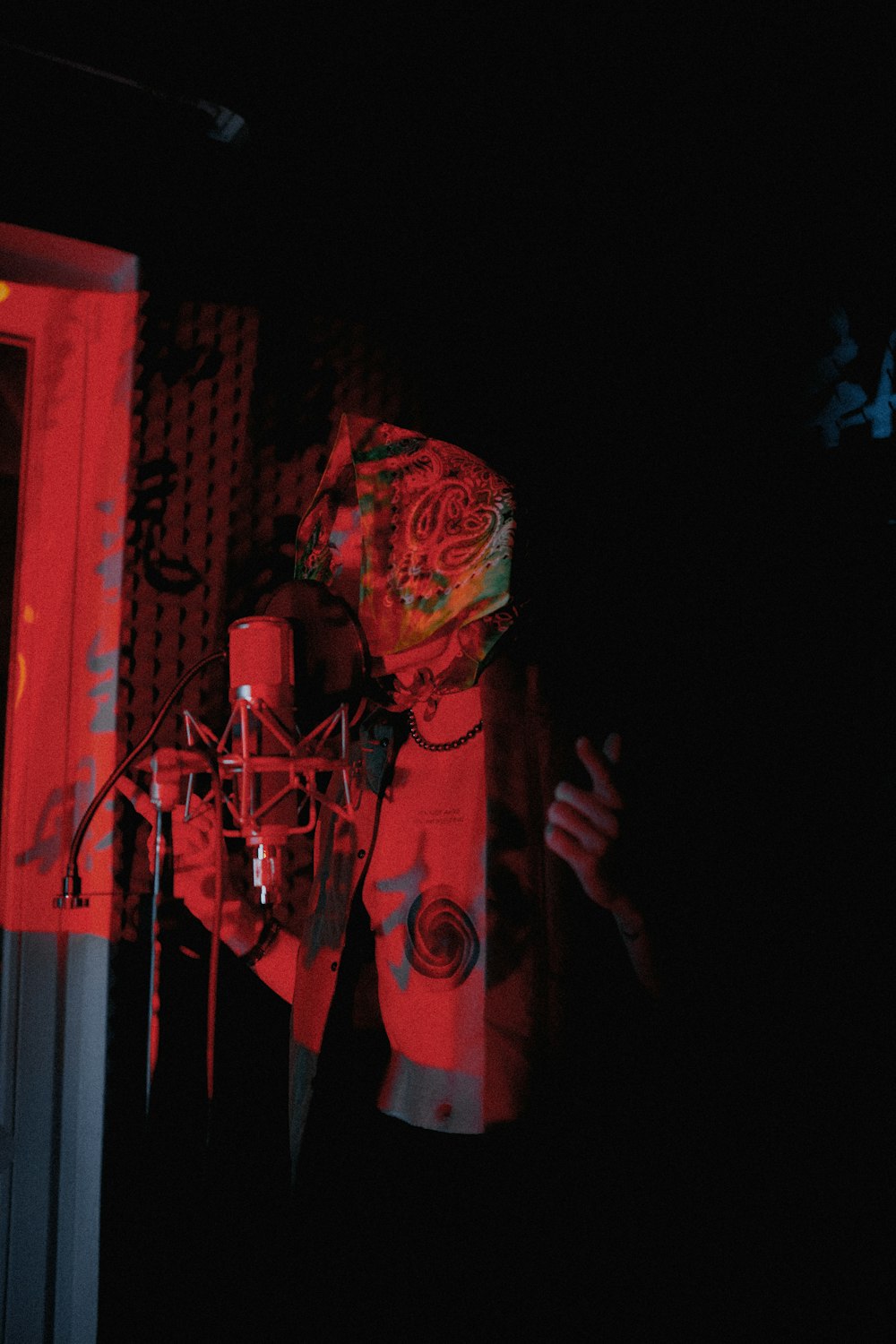 a man standing in front of a microphone in a dark room