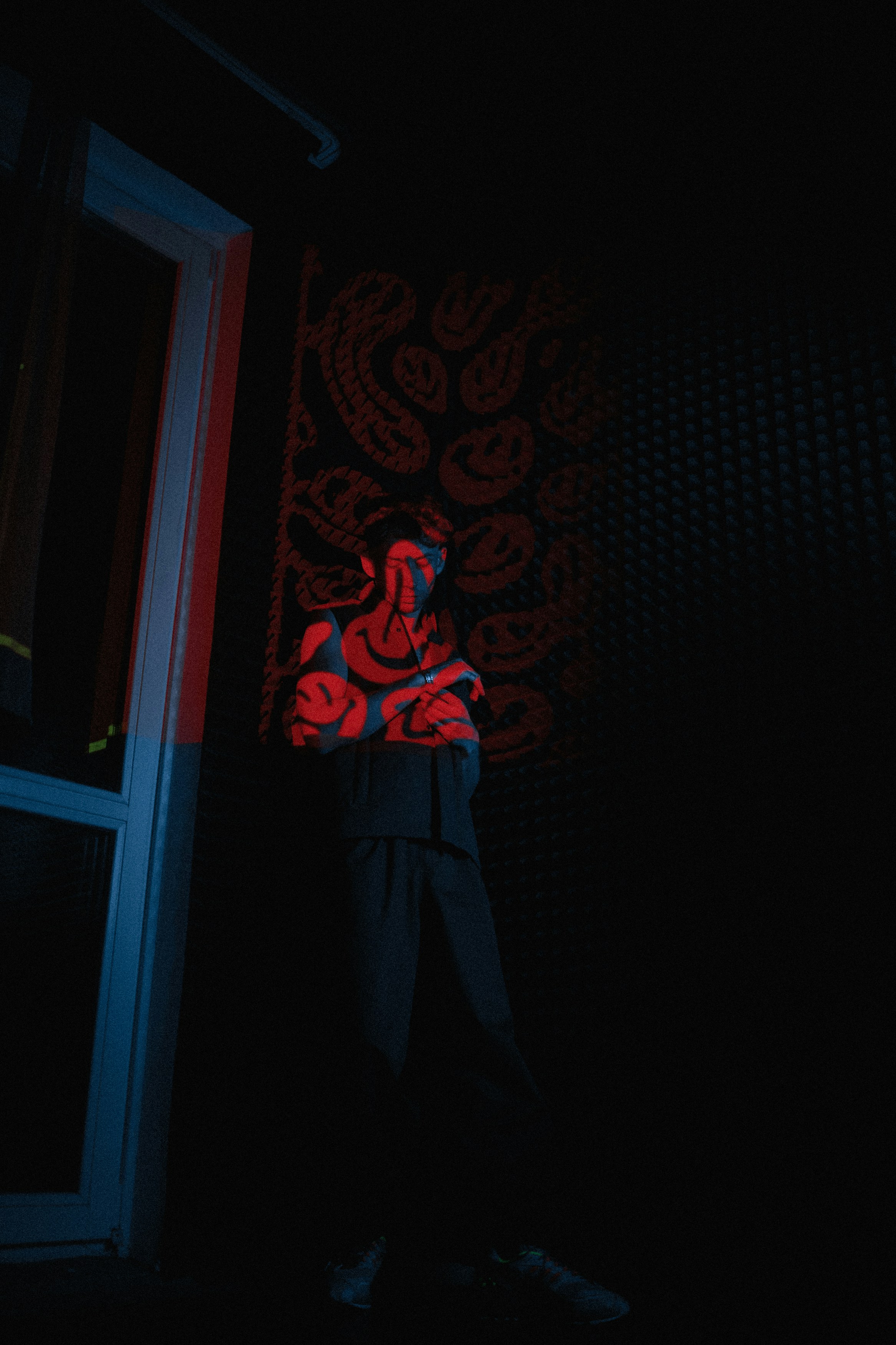 a man standing in the dark with his arms crossed