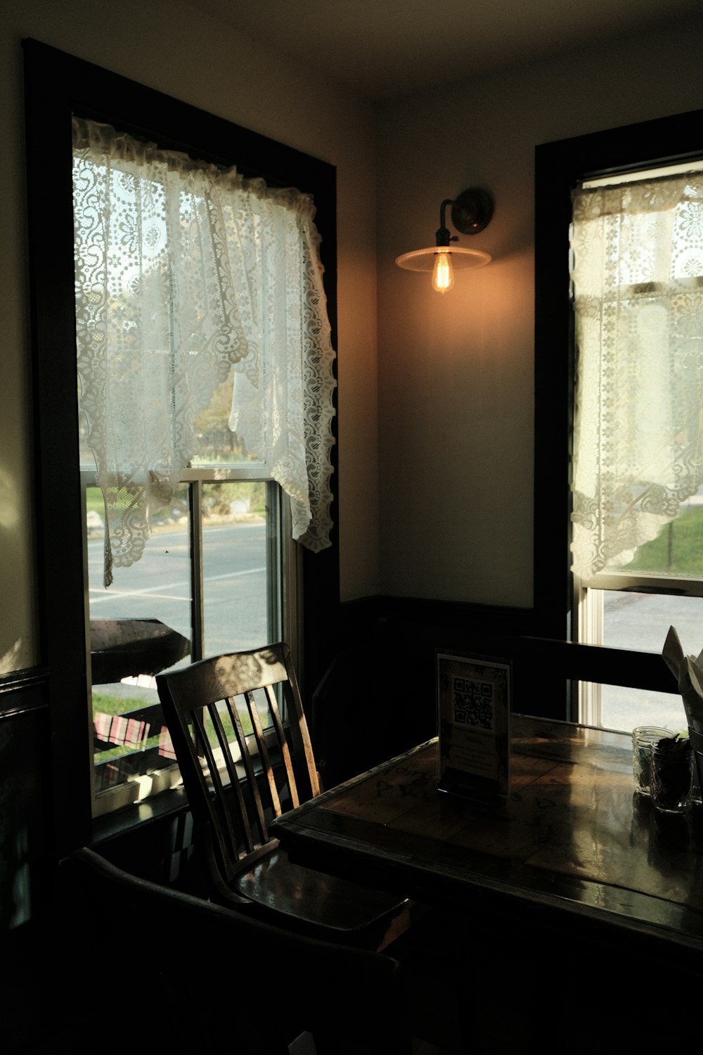 두 개의 창문이 있는 방의 테이블과 의자