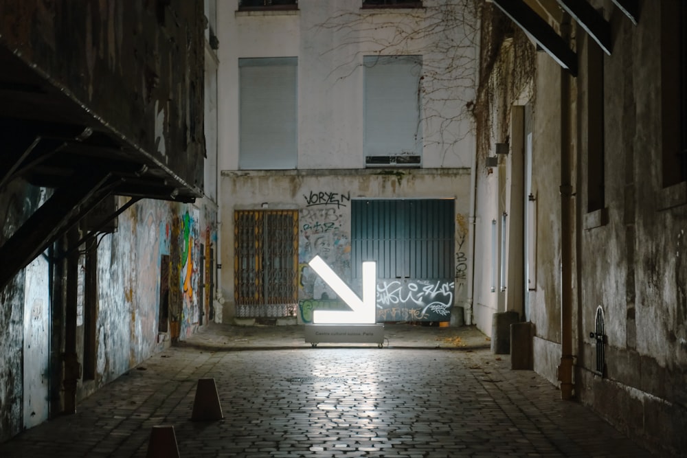 a narrow alleyway with graffiti on the walls