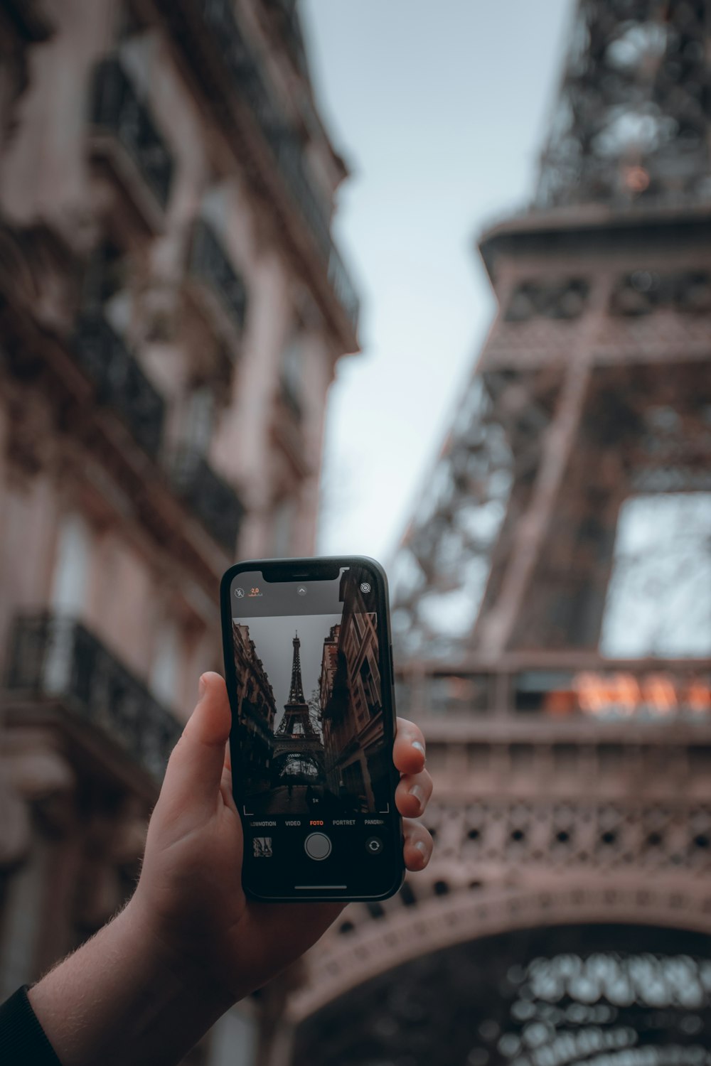 a person taking a picture of the eiffel tower