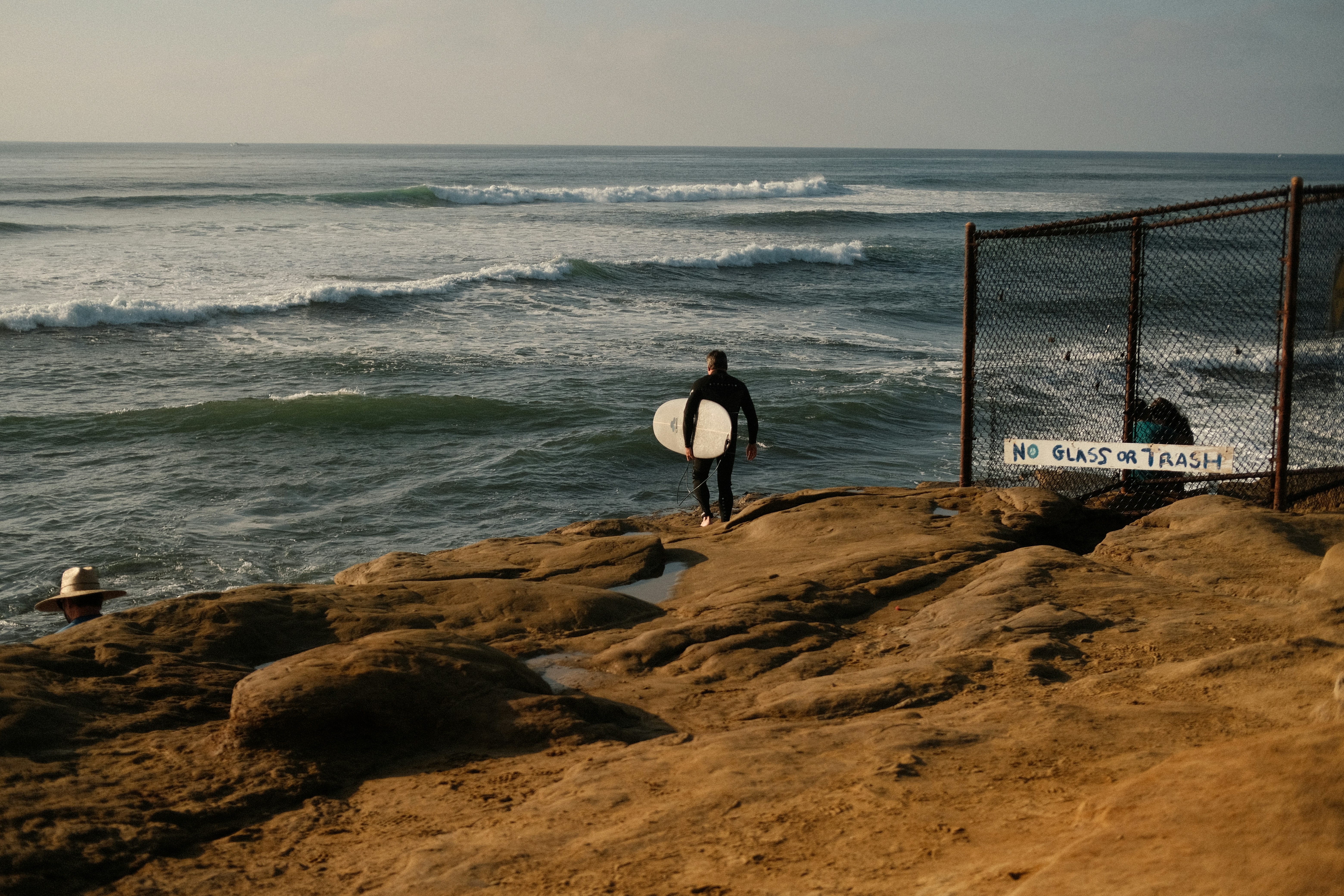a man holding a surfboard standing next to the ocean
