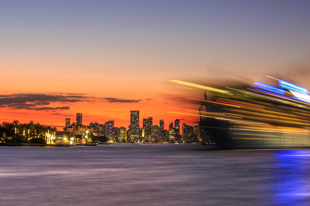 a large cruise ship in the water with a city in the background