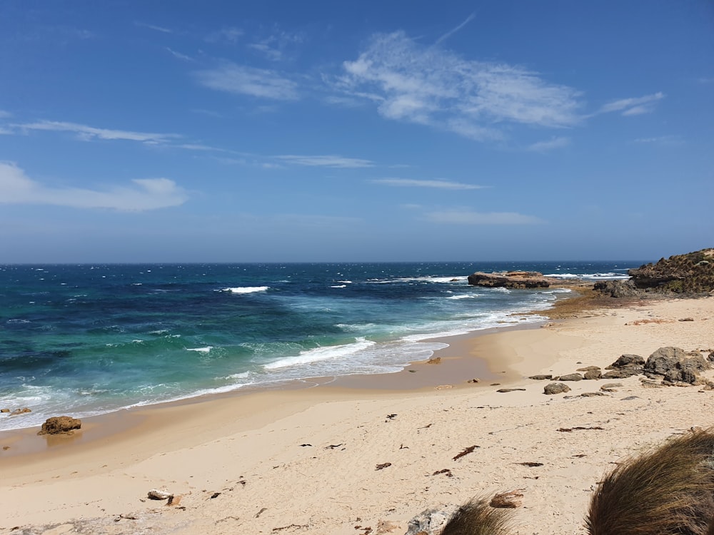 a sandy beach with waves coming in from the ocean